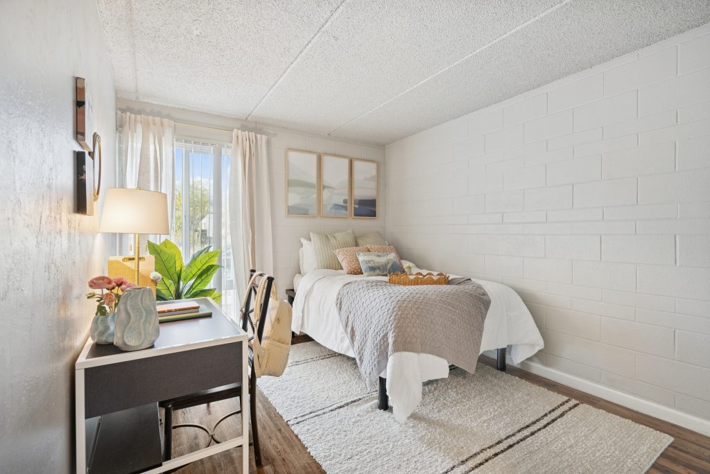 model bedroom with a desk and large window