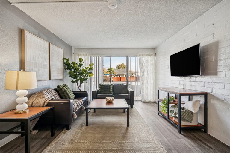 model living room with vinyl plank flooring and white brick wall
